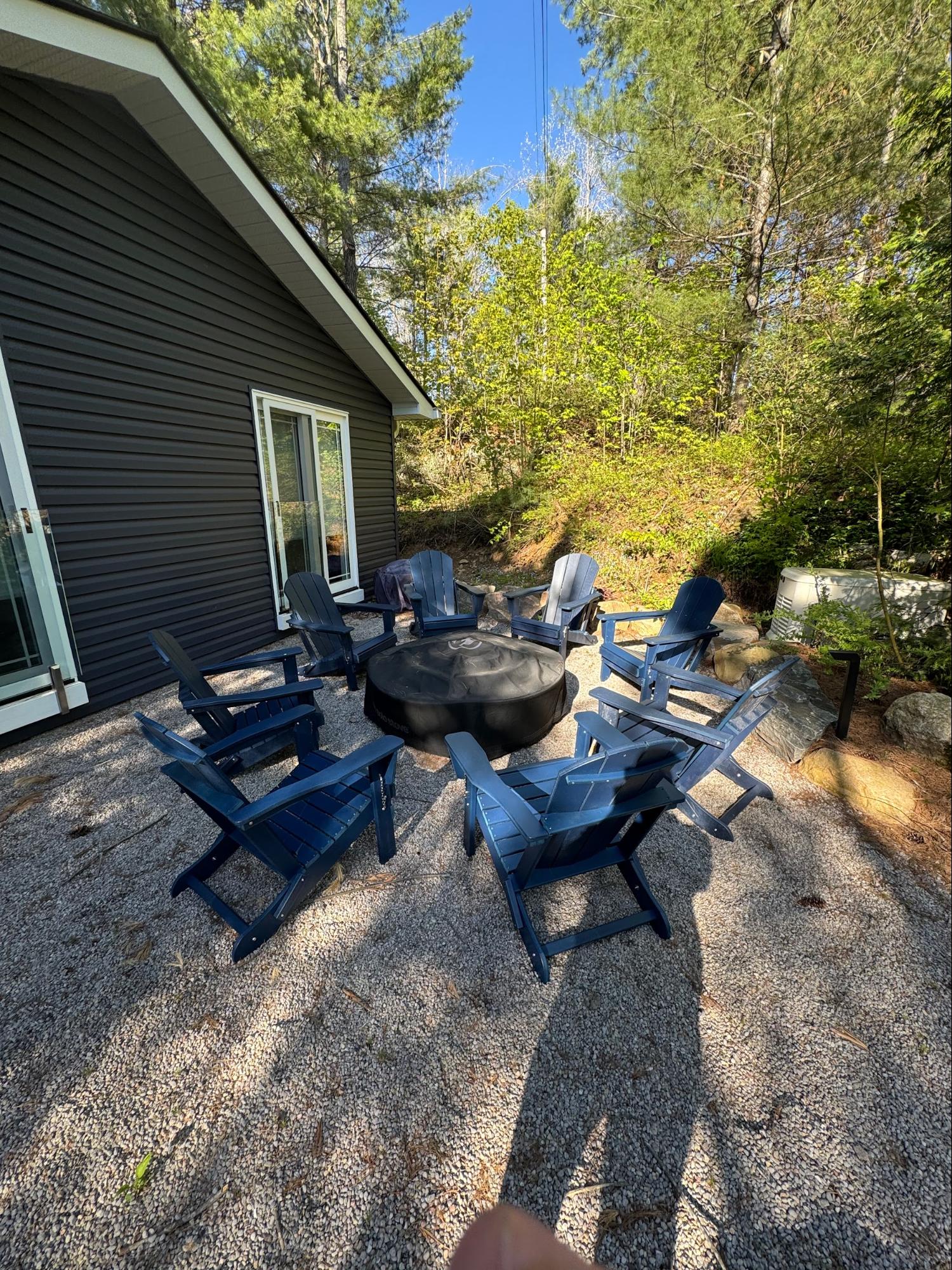 Fire pit with blue Muskoka chairs on gravel